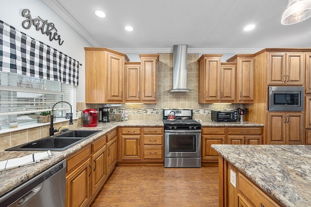 kitchen featuring wall chimney exhaust hood, stainless steel appliances, tasteful backsplash, sink, and ornamental molding