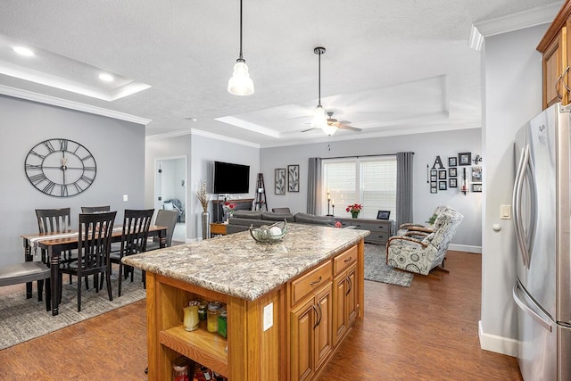 kitchen featuring a kitchen island, stainless steel fridge, a raised ceiling, ceiling fan, and crown molding