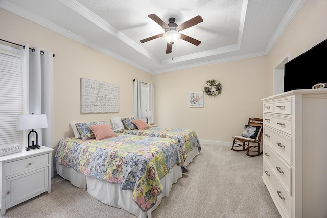 carpeted bedroom featuring ceiling fan, a tray ceiling, ornamental molding, and a textured ceiling