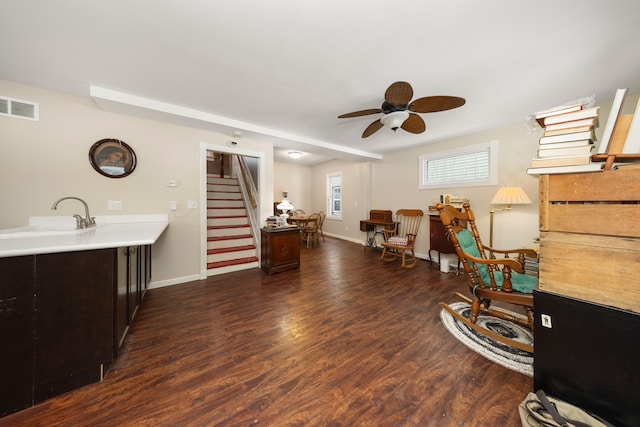 living area featuring ceiling fan, dark hardwood / wood-style floors, and sink