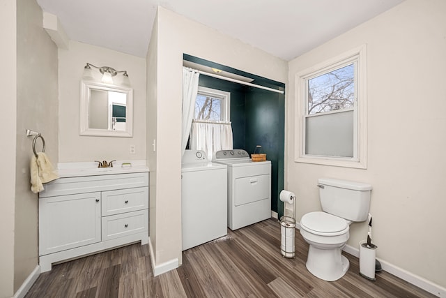 bathroom with toilet, hardwood / wood-style floors, washer and dryer, a wealth of natural light, and vanity