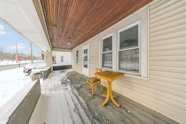 snow covered deck with a porch