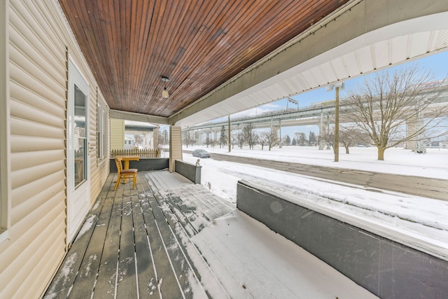 snow covered deck with a porch