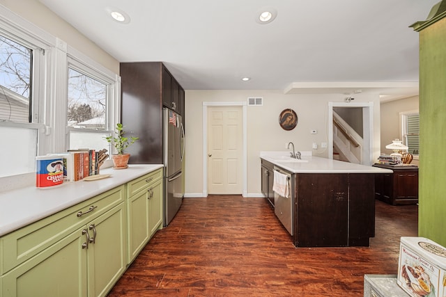 kitchen with dark hardwood / wood-style floors, sink, stainless steel appliances, and green cabinets