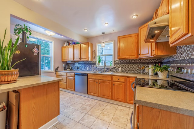 kitchen featuring light tile patterned floors, appliances with stainless steel finishes, hanging light fixtures, range hood, and sink