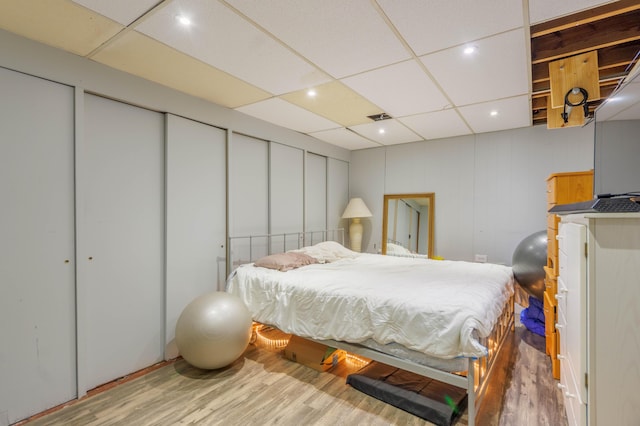 bedroom featuring a paneled ceiling and wood-type flooring