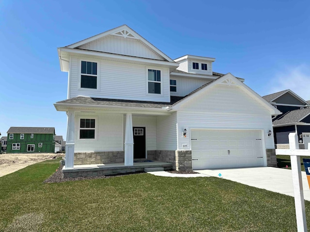 view of front of property featuring a front lawn, a garage, and covered porch