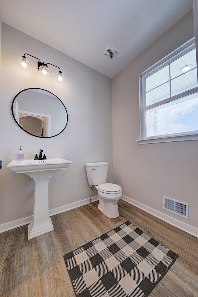 bathroom with toilet, sink, and hardwood / wood-style floors