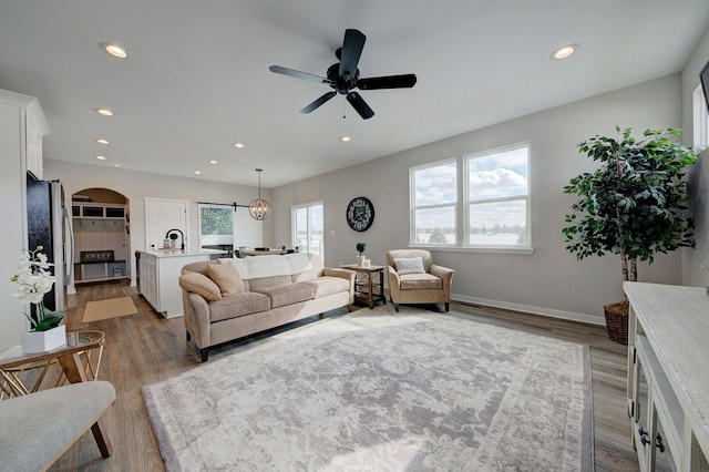 living room featuring hardwood / wood-style flooring, ceiling fan, and a healthy amount of sunlight