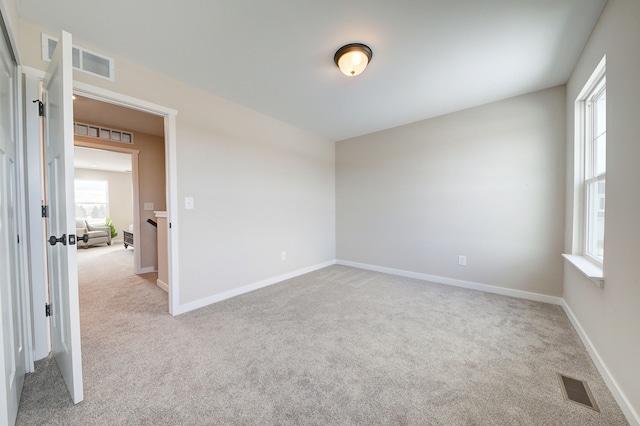 unfurnished room featuring light colored carpet