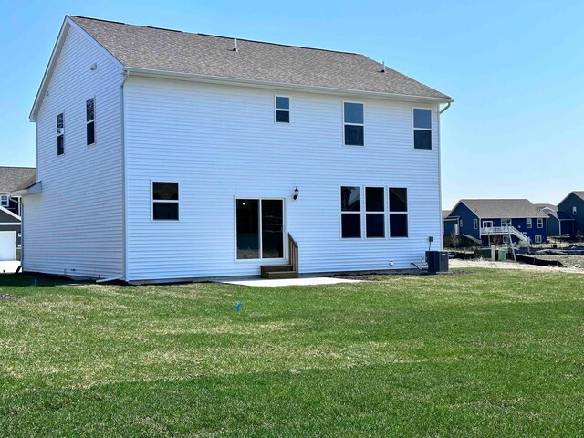 rear view of house featuring central air condition unit, a patio, and a yard