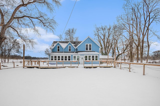 snow covered house featuring a wooden deck