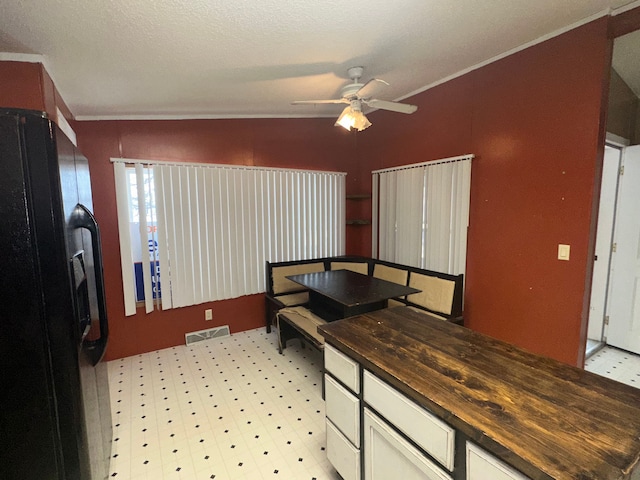 dining space with ceiling fan and ornamental molding