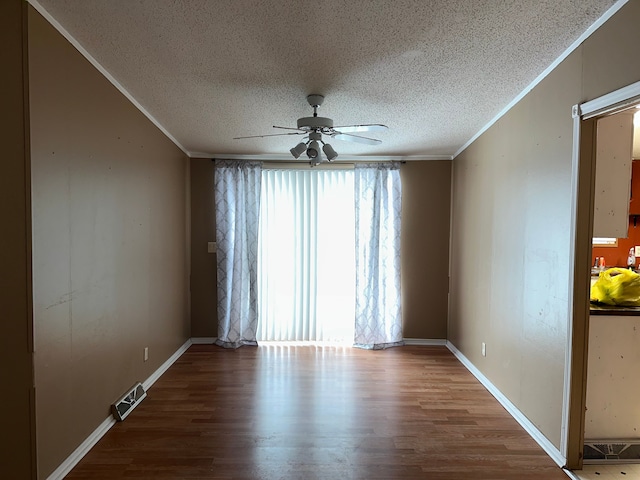 spare room with a textured ceiling, ceiling fan, crown molding, and hardwood / wood-style floors