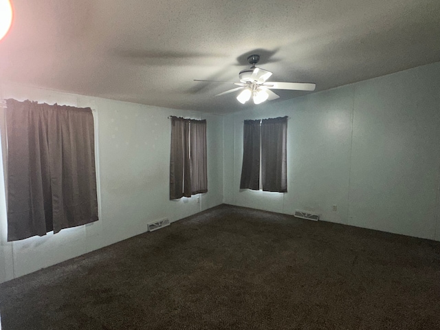 empty room featuring ceiling fan, a textured ceiling, and carpet flooring