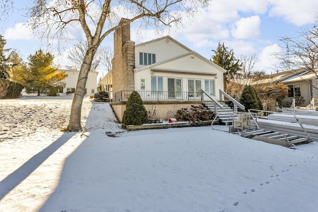 view of snow covered rear of property