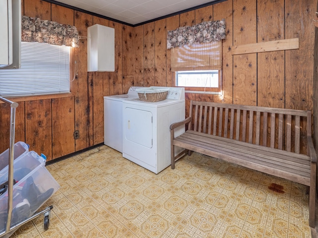 laundry area featuring laundry area, light floors, independent washer and dryer, and wooden walls