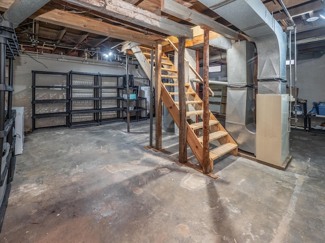 unfinished basement featuring washer / clothes dryer, water heater, and stairs