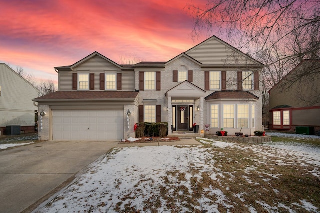 view of front of house featuring a garage and central AC