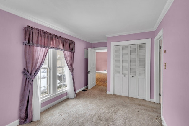 unfurnished bedroom featuring light carpet, a closet, and crown molding