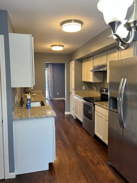 kitchen featuring white cabinets, appliances with stainless steel finishes, dark wood-type flooring, sink, and light stone counters