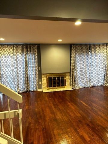 basement with a large fireplace and hardwood / wood-style floors