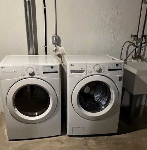 clothes washing area with washer and clothes dryer and sink