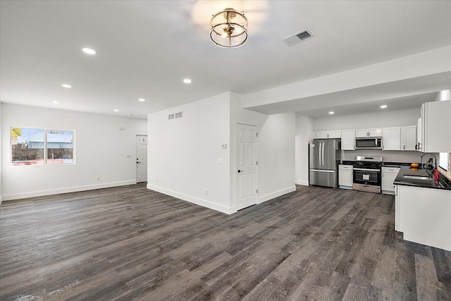 kitchen with dark hardwood / wood-style floors, stainless steel appliances, white cabinetry, and sink