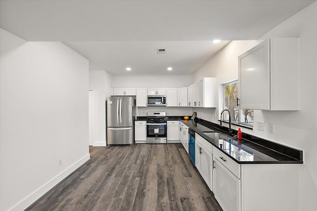 kitchen with white cabinets, appliances with stainless steel finishes, sink, and dark hardwood / wood-style floors