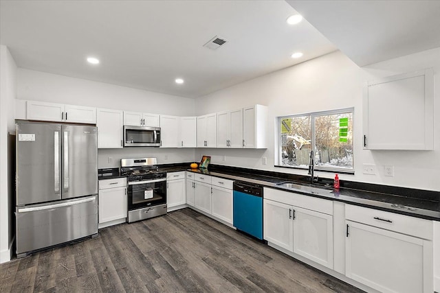 kitchen featuring appliances with stainless steel finishes, dark hardwood / wood-style flooring, white cabinetry, and sink