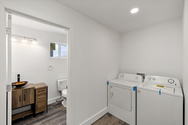 laundry room with dark hardwood / wood-style floors and washing machine and clothes dryer