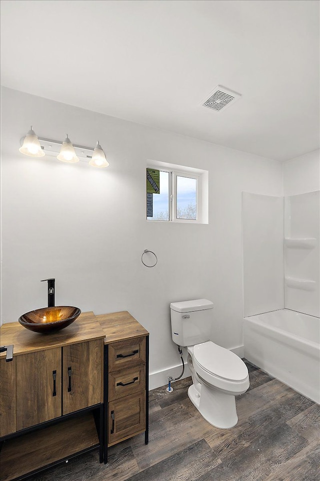 bathroom with toilet, hardwood / wood-style floors, and vanity