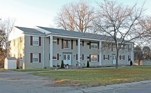 view of front facade with a front lawn and a shed