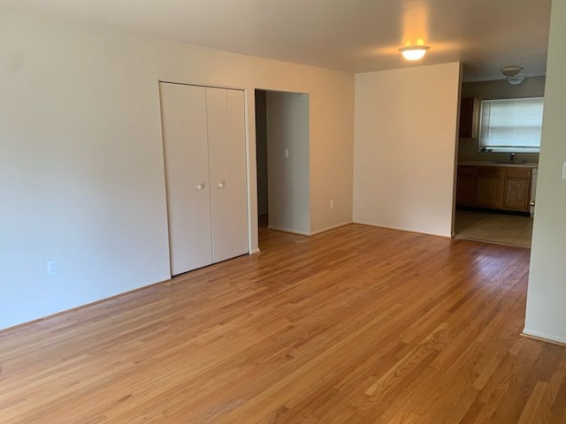 unfurnished room featuring light wood-type flooring and sink