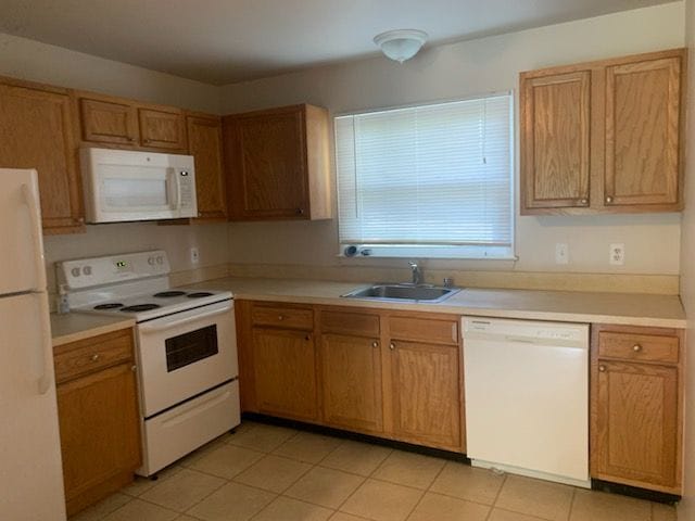 kitchen with sink, white appliances, and light tile patterned floors