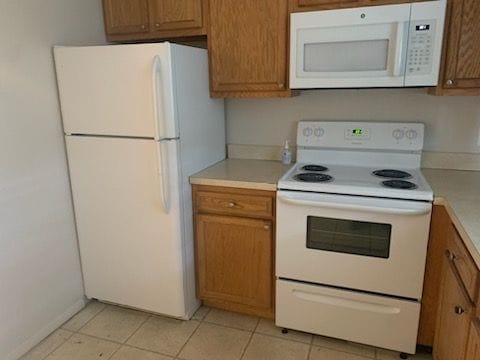 kitchen featuring light tile patterned floors and white appliances