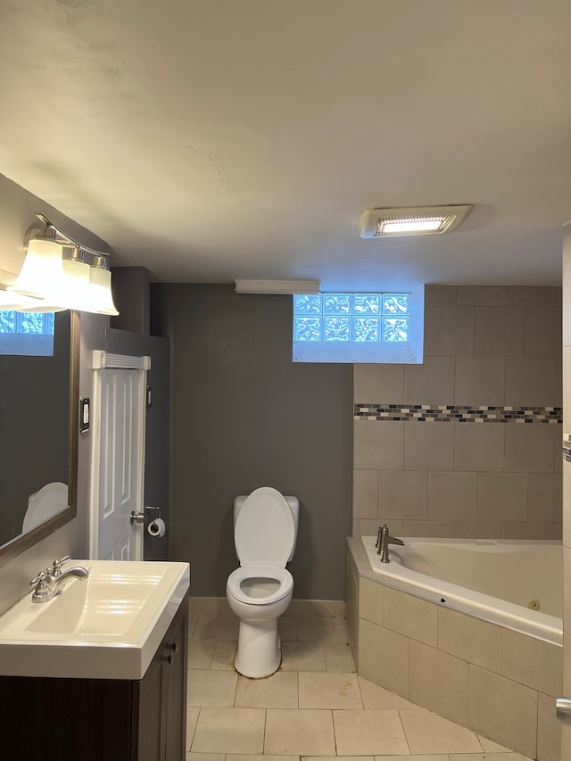 bathroom featuring tiled bath, tile patterned floors, vanity, and toilet