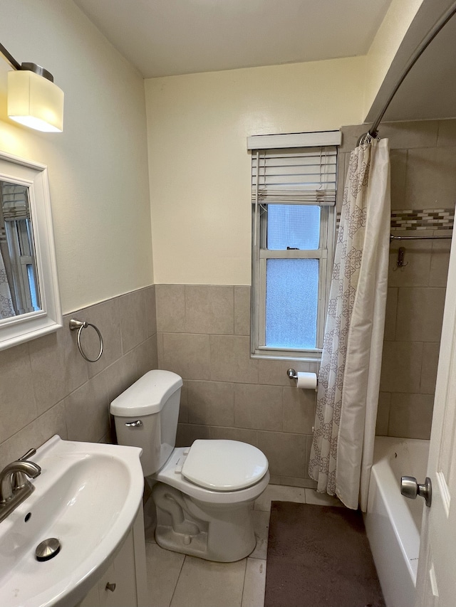 full bathroom with tile patterned floors, sink, tile walls, toilet, and shower / bath combo with shower curtain