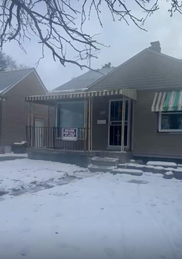 view of snow covered back of property