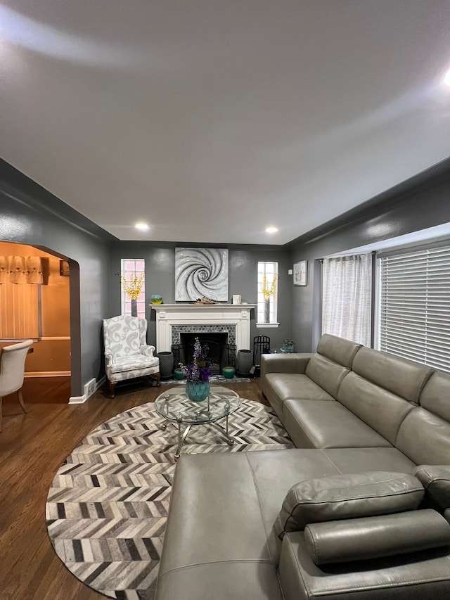 living room with dark wood-type flooring and a fireplace