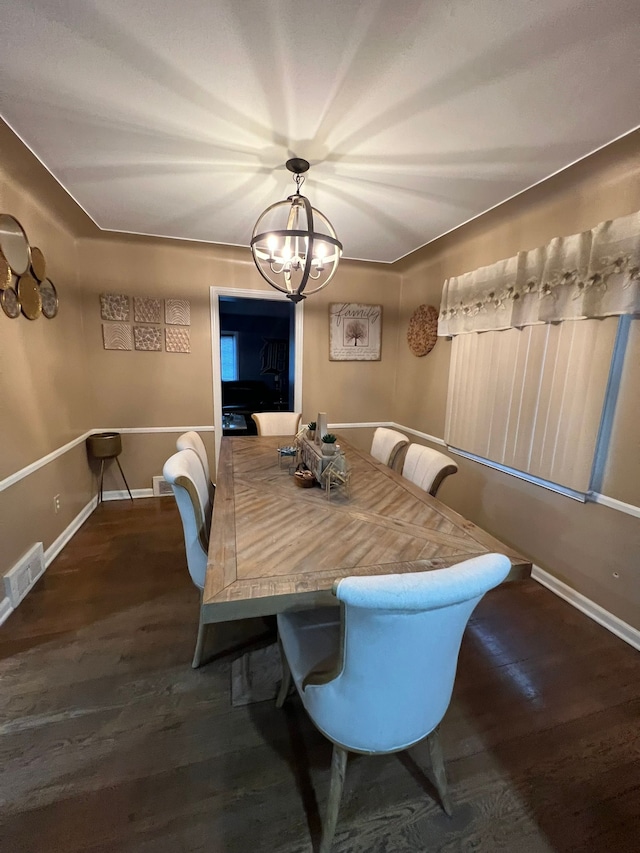 dining room with dark hardwood / wood-style floors and an inviting chandelier