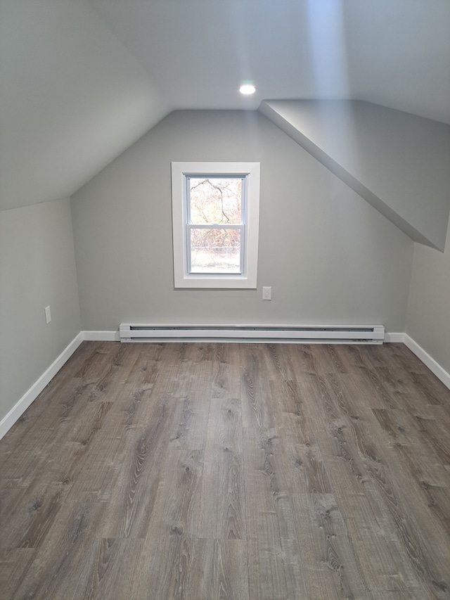 bonus room featuring lofted ceiling, hardwood / wood-style floors, and a baseboard radiator