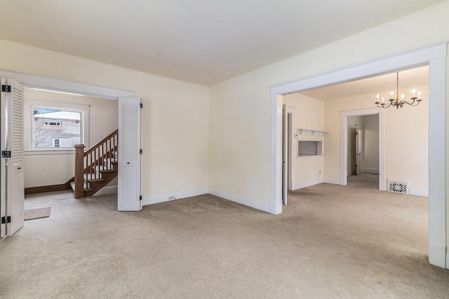 carpeted empty room featuring a chandelier