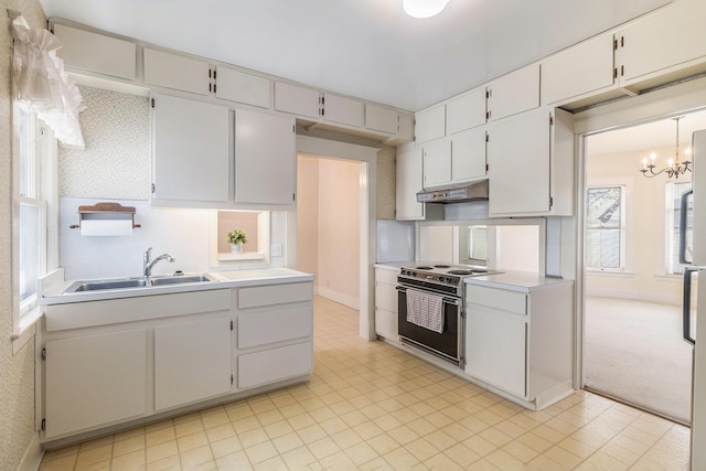 kitchen featuring decorative light fixtures, a notable chandelier, electric range oven, sink, and white cabinetry