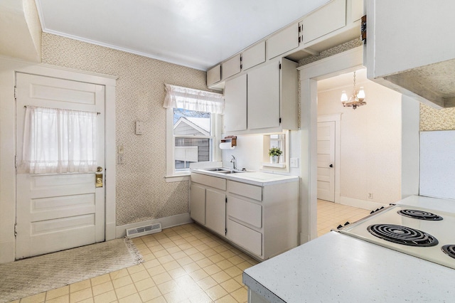 kitchen featuring white cabinetry, sink, hanging light fixtures, and ornamental molding