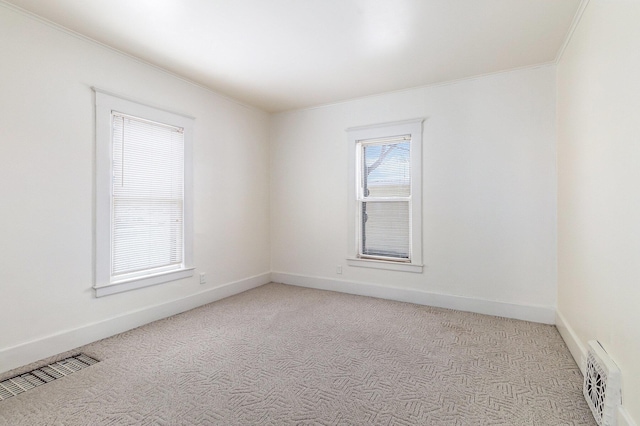 carpeted spare room featuring ornamental molding