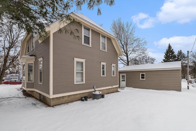 snow covered property featuring central AC unit