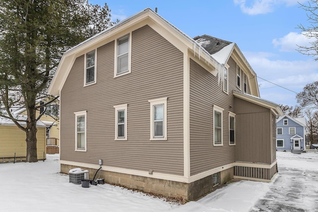 snow covered property featuring cooling unit