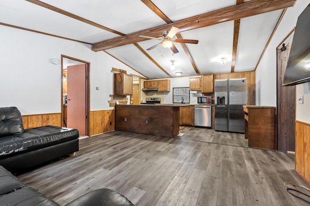 kitchen featuring hardwood / wood-style floors, ceiling fan, appliances with stainless steel finishes, vaulted ceiling with beams, and sink