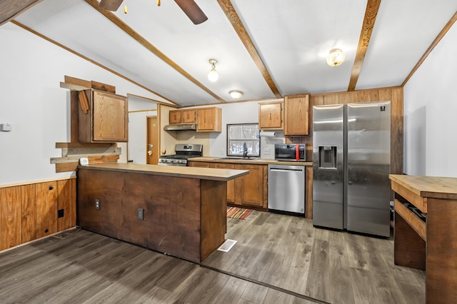 kitchen featuring kitchen peninsula, stainless steel appliances, dark wood-type flooring, vaulted ceiling, and sink